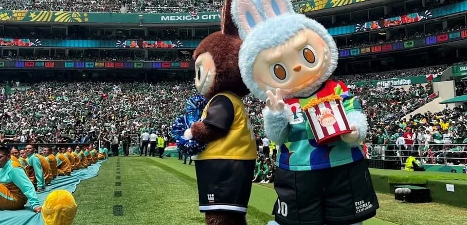 Ikki maskot stadionda tomoshabinlar oldida turibdi