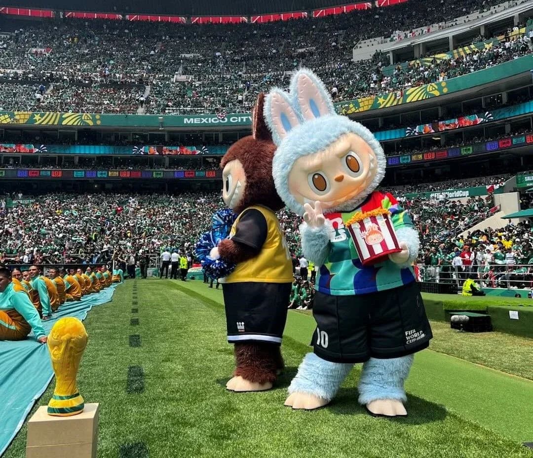 Ikki maskot stadionda tomoshabinlar oldida turibdi