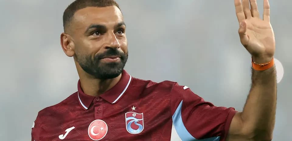 Futbolchi qo'lini ko'tarib muxlislarga salom berayapti