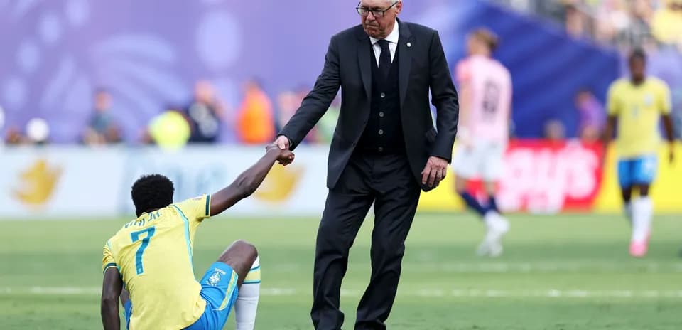 Coach helping player up during match on field