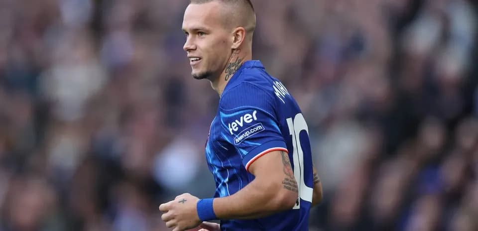 Futbolchi maydonda harakatda, ko'k formada