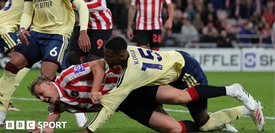Players in a tackle during a football match