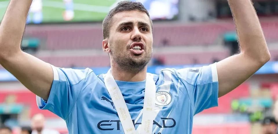 Futbolchi medali bilan maydonda quvonchli holatda