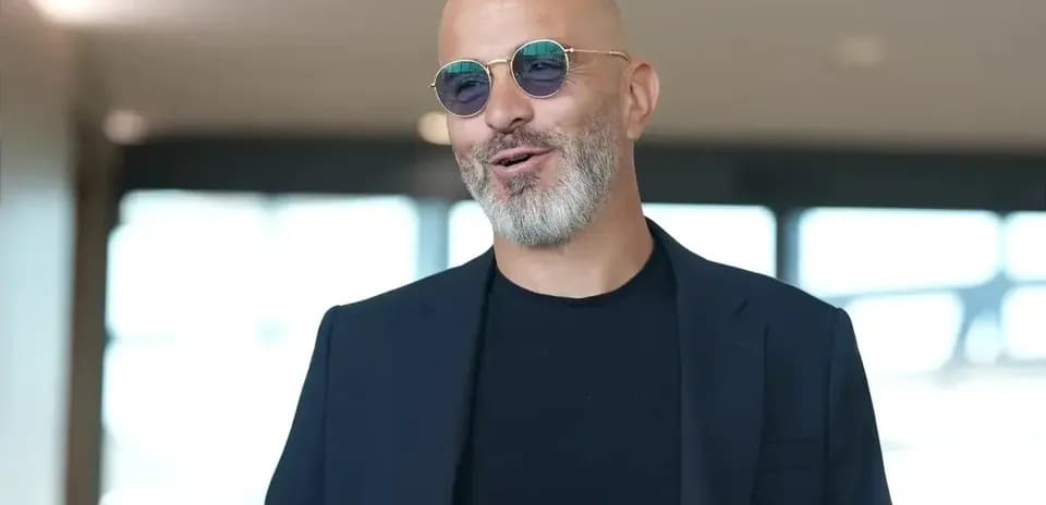 Man in sunglasses smiling indoors
