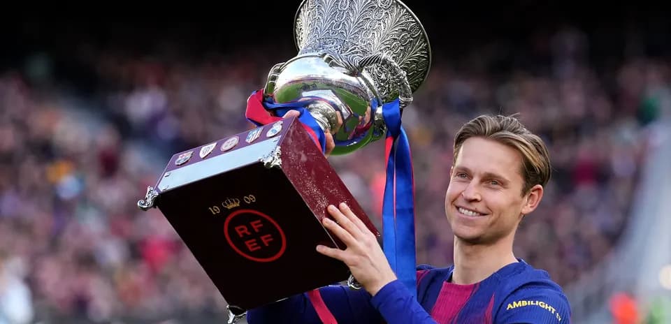 Futbolchi kubokni ko'tarib turib tabriklayapti