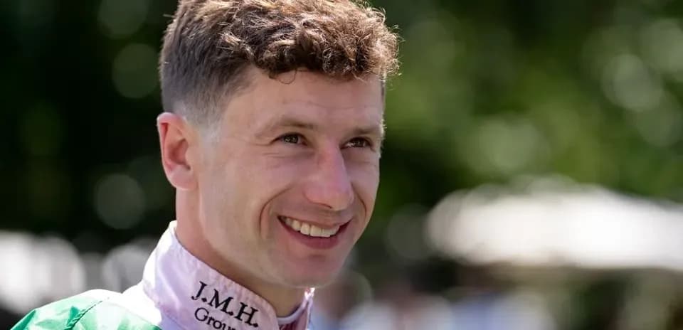Jockey smiling in racing attire outdoors