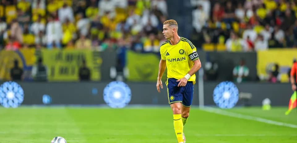 Futbolchi maydonda to'p bilan harakatlanmoqda