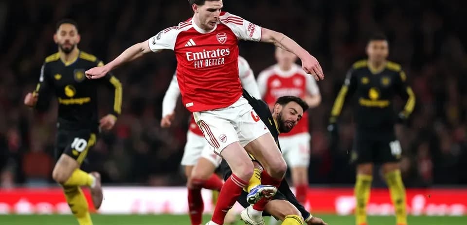 Arsenal player evading opponent during a match