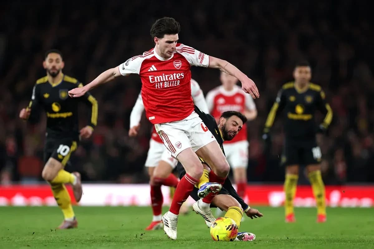 Arsenal player evading opponent during a match