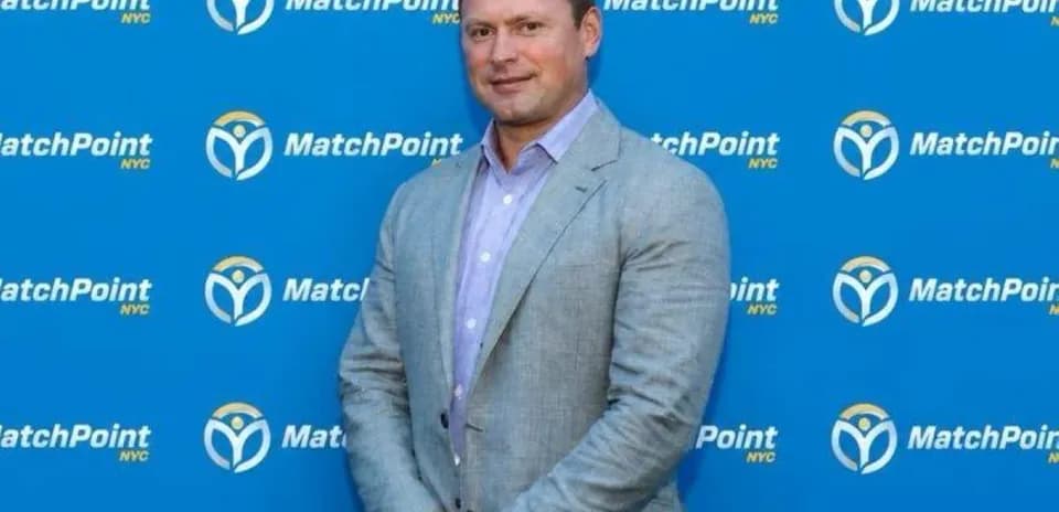 Man in suit posing in front of MatchPoint backdrop