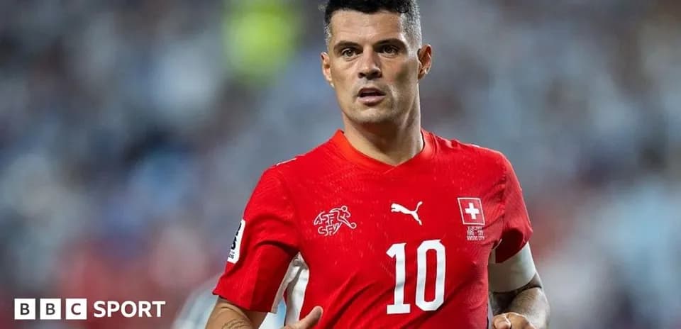 Futbolchi maydonda harakatlanmoqda, Shveysariya formasi kiygan