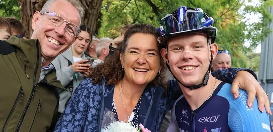 Three people celebrating with flowers after cycling event