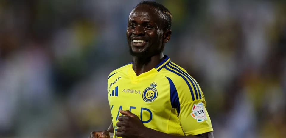 Futbolchi maydonda yurgan va tabassum qilayotgan