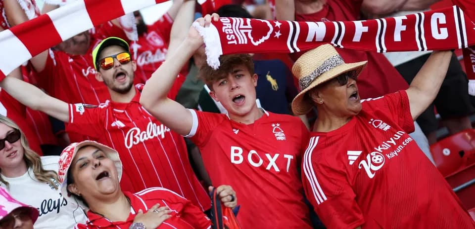 Fans cheering and waving scarves in stadium