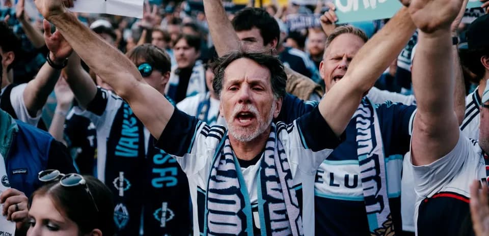 Vancouver Whitecaps fans cheering with banners