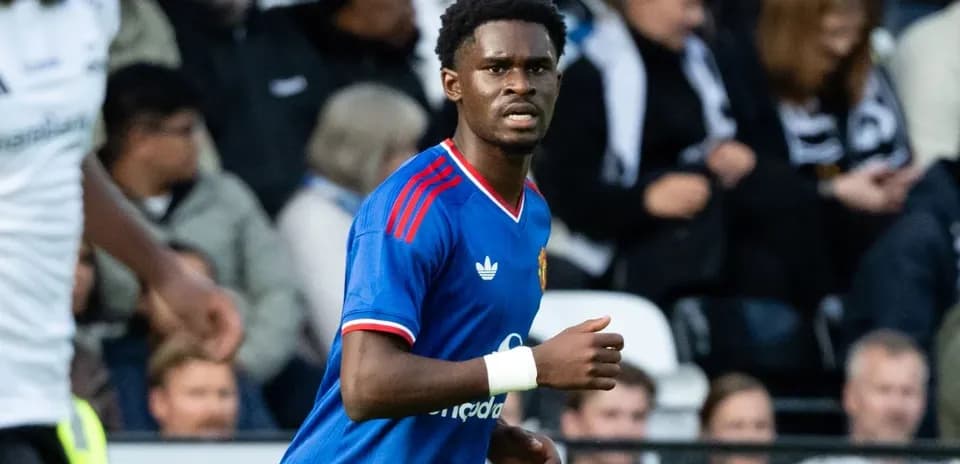 Futbolchi maydonda harakatda, tomoshabinlar orqasida