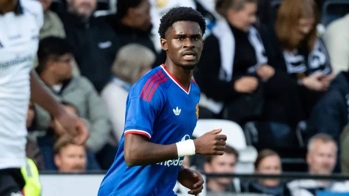 Futbolchi maydonda harakatda, tomoshabinlar orqasida