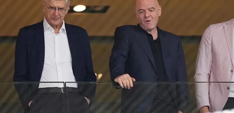Two men conversing in a stadium box