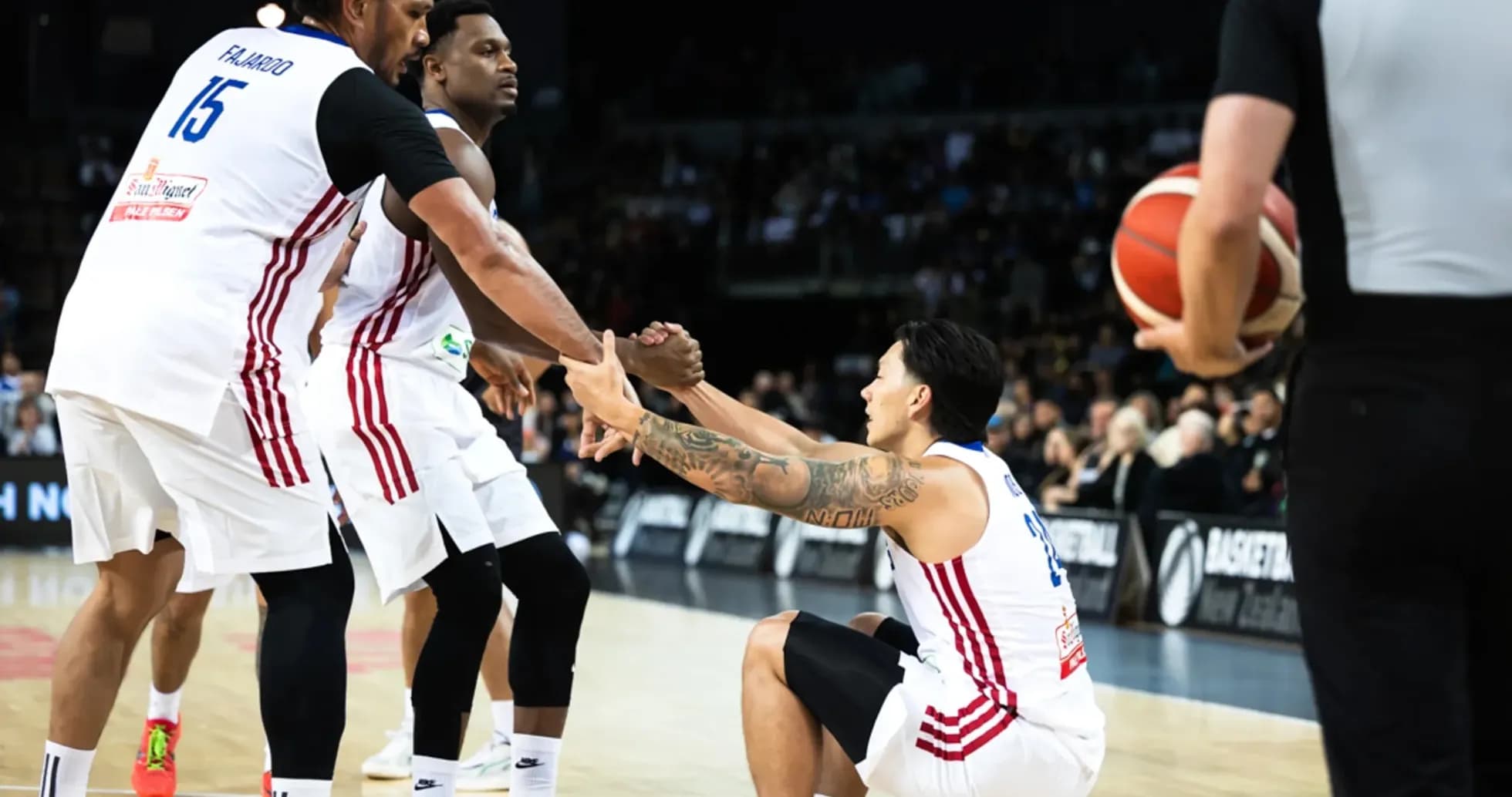 Two players helping teammate get up during game