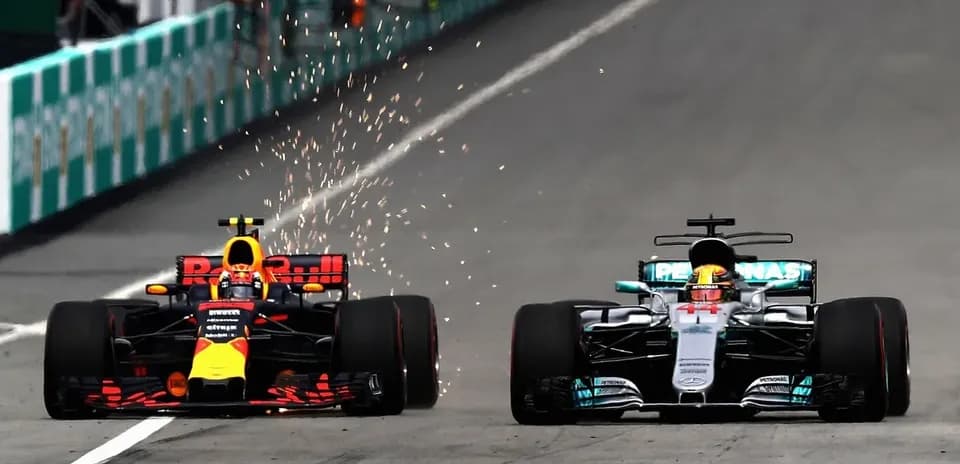Red Bull and Mercedes cars racing with sparks flying