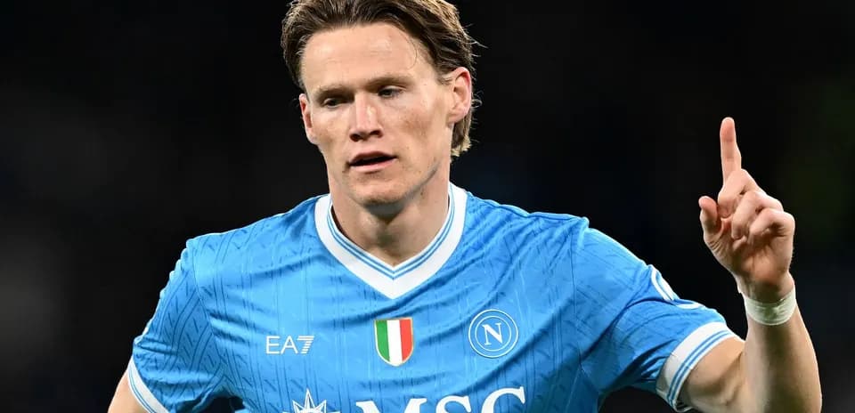 Futbolchi Napoli formasida maydonda ko'rsatkich berayotgan