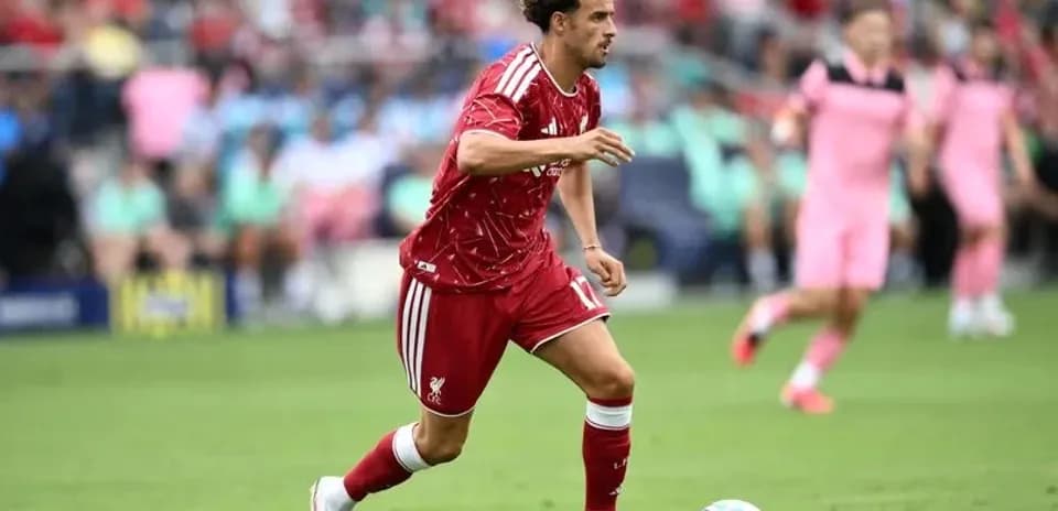 Futbolchi to'pni ushlab, yugurayotgan paytda