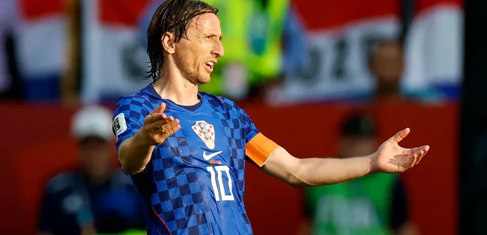 Futbolchi maydonda qo'llarini ochib turibdi