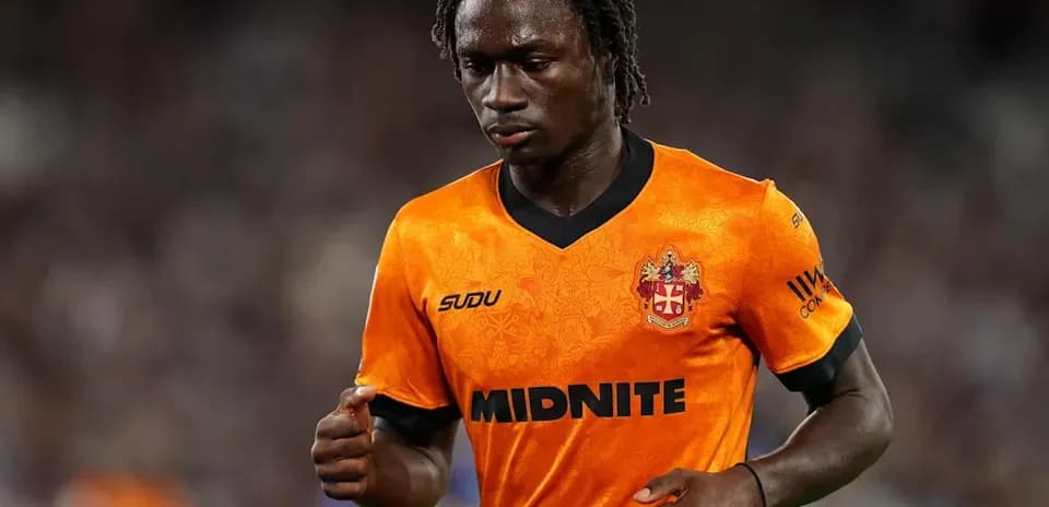 Futbolchi orange forma kiygan maydonda yurmoqda