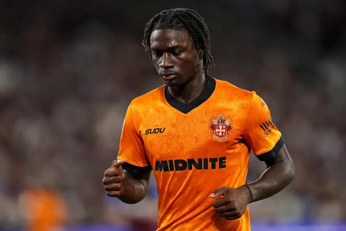 Futbolchi orange forma kiygan maydonda yurmoqda