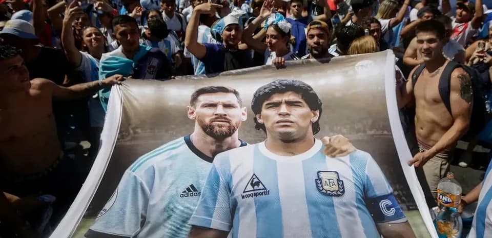 Fans holding banner of Messi and Maradona in crowd