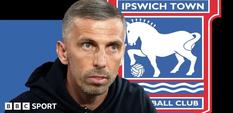 Manager speaking in front of Ipswich Town logo