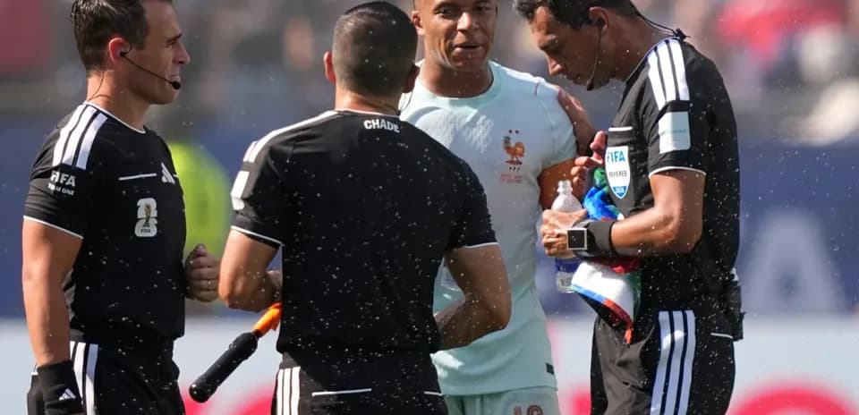 Kylian Mbappé speaking with referees during match