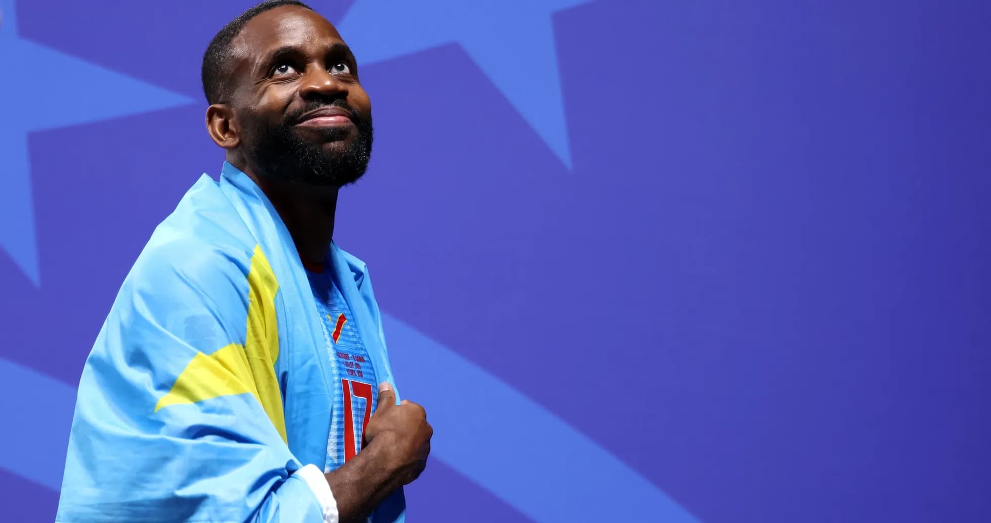 Athlete wearing flag, looking up during event