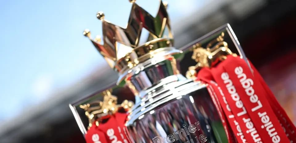 Premier League trophy with red ribbons displayed