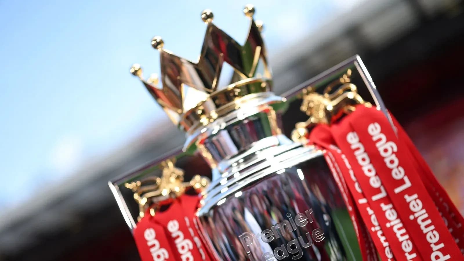 Premier League trophy with red ribbons displayed