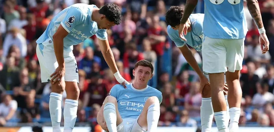 Manchester City players attending to injured teammate