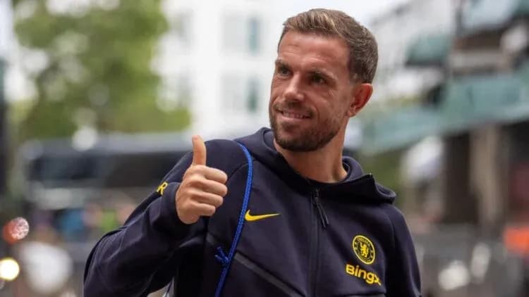 Futbolchi Chelsea formasida ko'cha bo'ylab yurmoqda