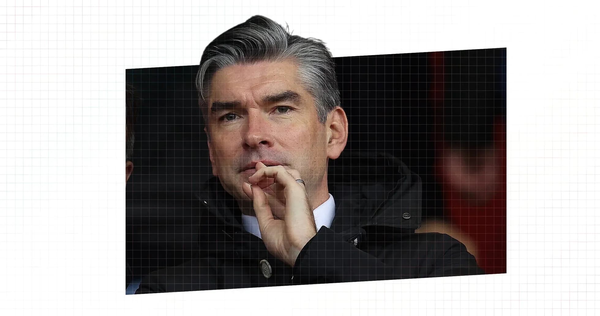 Man in coat observing match from the stands