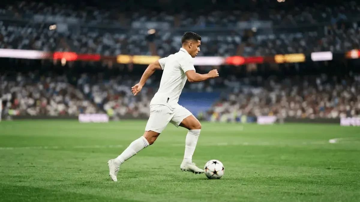 Futbolchi to'p bilan yugurmoqda