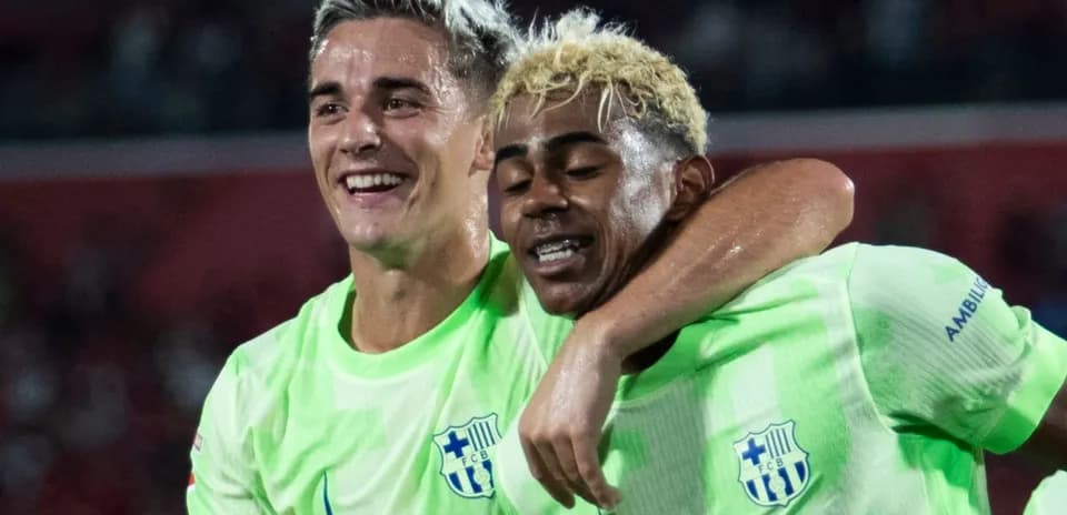 Ikkita futbolchi bir-birini quchib turib tabassum qilmoqda