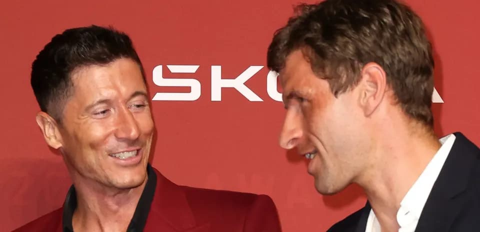 Ikki futbolchi qizil fon oldida suhbatlashmoqda