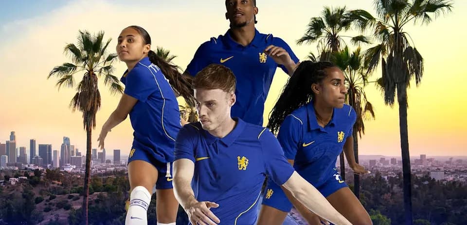 Football players posing in blue kits with city skyline