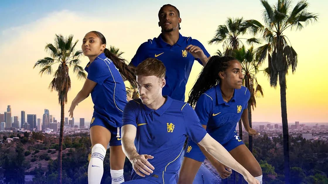 Football players posing in blue kits with city skyline