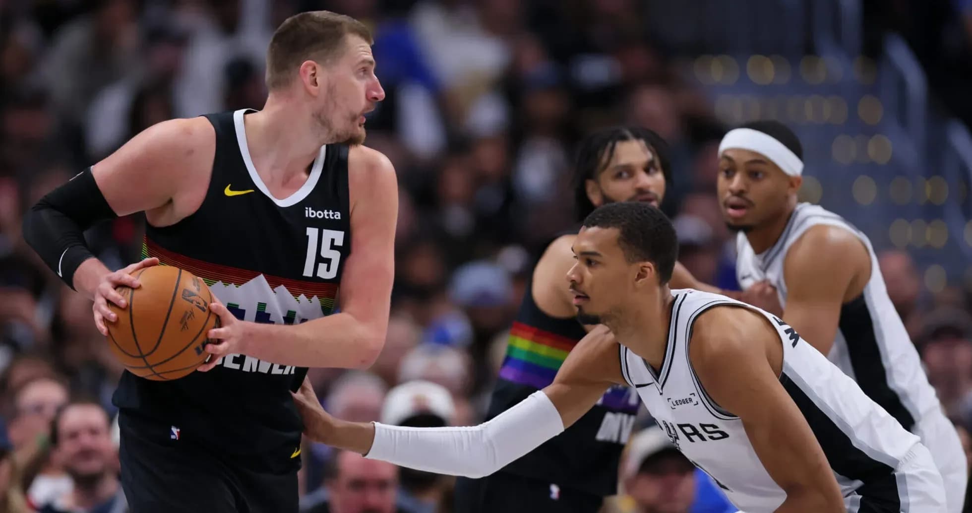 Jokic dribbling while defended by Spurs player