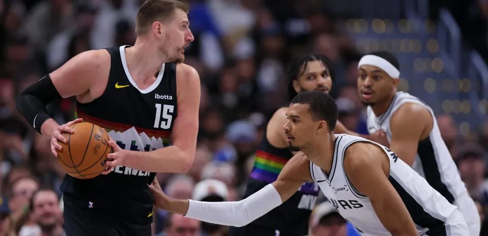 Jokic dribbling while defended by Spurs player