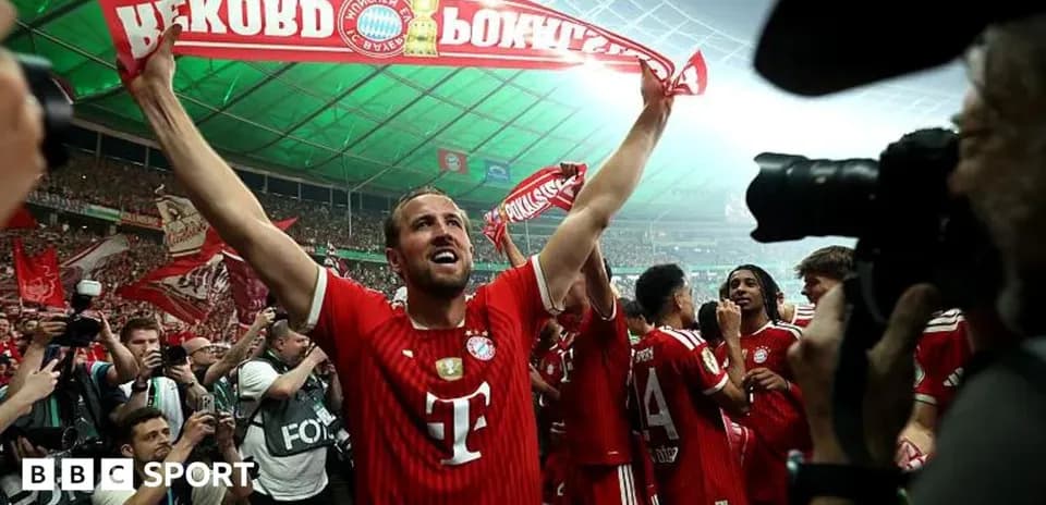 Futbolchi kubokni qo'lida ushlab turibdi