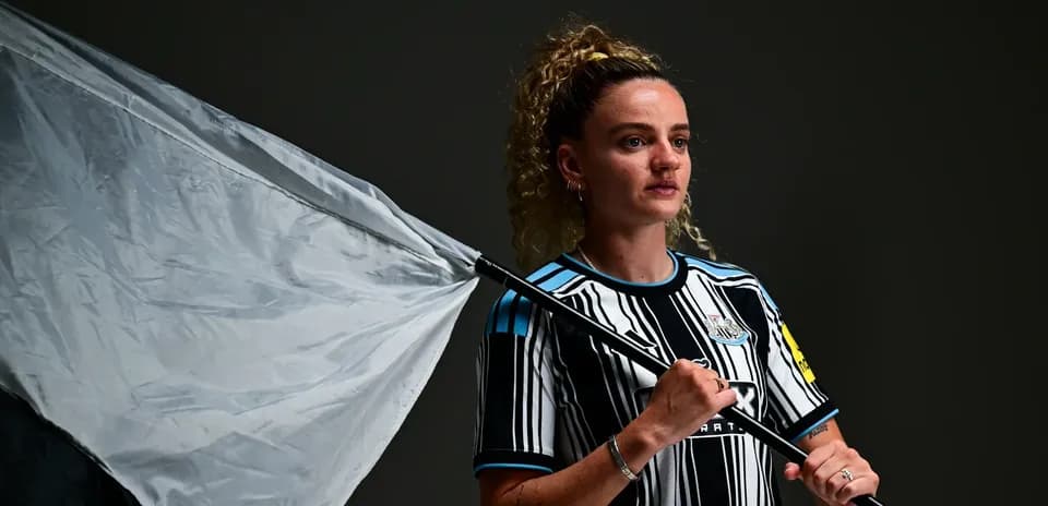 Ayol futbolchi bayroq bilan poz berayotgan