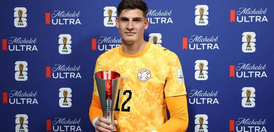 Goalkeeper holding trophy at press event