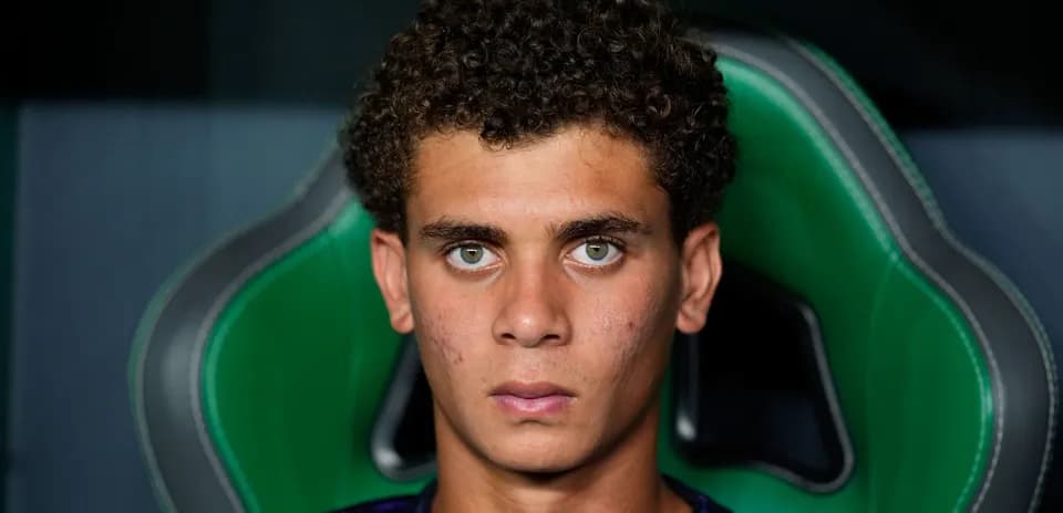 Young player seated in sports chair, serious expression