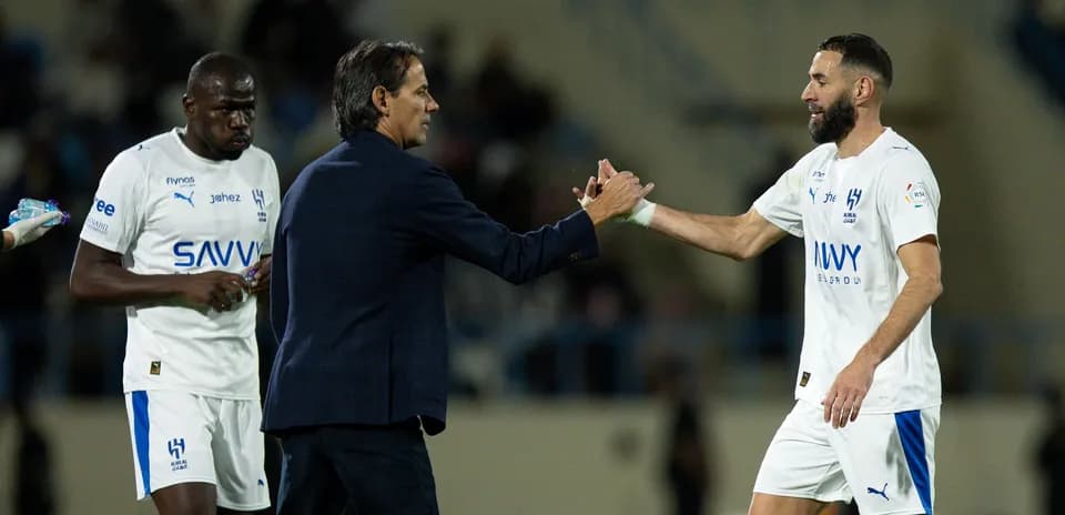 Trener va futbolchi qo'l berishmoqda